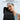 Person wearing lightweight black back brace with adjustable lumbar pad for lower back pain relief.